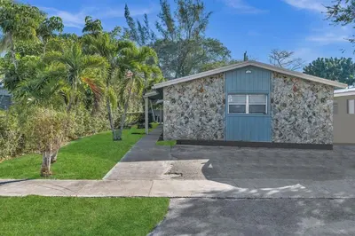 a house with a blue garage and palm trees at Hollywood 2 Bdrm New Furnished Beach Vacation LB2 in Hollywood