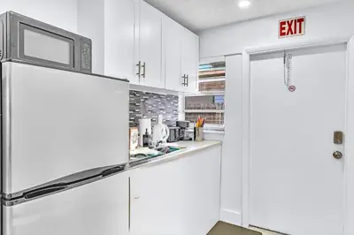 a kitchen with white cabinets and a refrigerator at Hollywood Large Studio Close to Beach & Casino LB3 in Hollywood