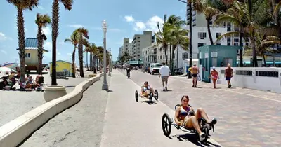 a couple of people riding in wheelbarrows on a beach at Hollywood Large Studio Close to Beach & Casino LB3 in Hollywood