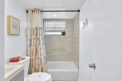 a white bathroom with a shower and a toilet at Hollywood Large Studio Close to Beach & Casino LB3 in Hollywood