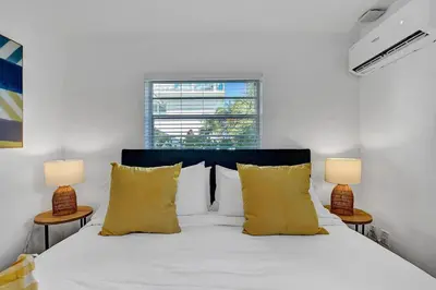 a bedroom with a white bed with two lamps at Waves On Desoto Rental Unit With Pool in Hollywood