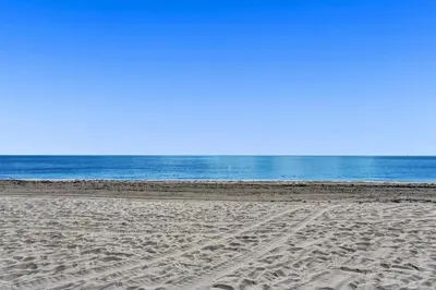 a sandy beach with the ocean in the background at Waves On Desoto Rental Unit With Pool in Hollywood