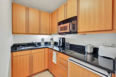 a kitchen with wooden cabinets and a microwave at Amazing private studio in Four Seasons Residences Brickell! in Miami