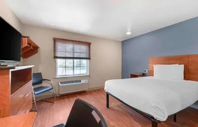 a bedroom with a large bed and a television at Extended Stay America Select Suites - Fort Lauderdale - Airport - West in Davie