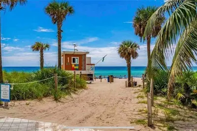 a beach house on the beach with palm trees at Beachfront Apartment in Miami Beach with Stunning Views 1A in Hallandale Beach