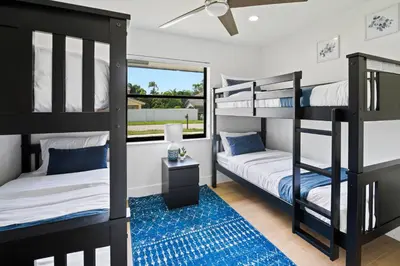 a bedroom with bunk beds and a blue rug at Villa Paradise Miami, Luxury Gem with Heated Pool, Game Room, Fire Pit, 3 Bed 2 Bath in Miami