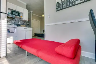 a red bench in a room with a kitchen at Sunny Miami Beach Condo Steps to Boardwalk! in Miami Beach
