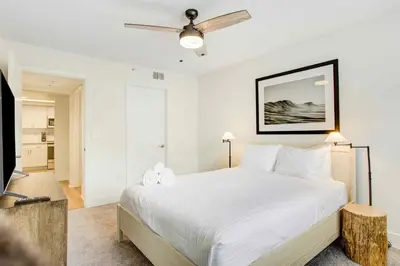 a bedroom with a large white bed with a ceiling fan at Tucker at Palm Trace Landings Fort Lauderdale in Davie