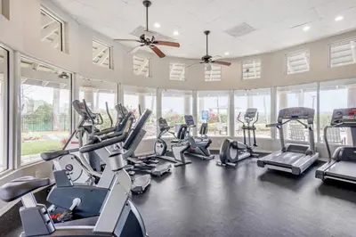 a gym with several treadmills and elliptical machines at Tucker at Palm Trace Landings Fort Lauderdale in Davie