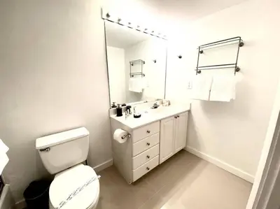 a bathroom with a toilet and a sink and a mirror at Zen Vacation Rentals Modern Penthouse Across Ocean in Miami Beach
