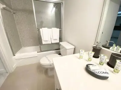 a white bathroom with a toilet and a shower at Zen Vacation Rentals Modern Penthouse Across Ocean in Miami Beach