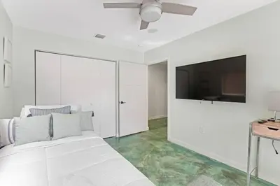 a white bedroom with a bed and a flat screen tv at Heated Pool I Soundproof Home I Firepit I 630Mbps in Hollywood