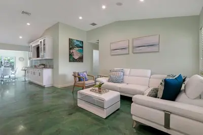 a living room with white furniture and a kitchen at Heated Pool I Soundproof Home I Firepit I 630Mbps in Hollywood