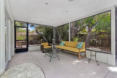 a screened in porch with a couch and a table at Heated Pool I Soundproof Home I Firepit I 630Mbps in Hollywood