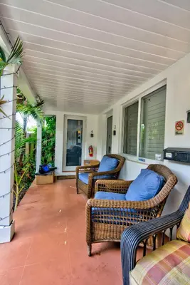a porch with two wicker chairs and a table at Efficiency 3 on water Las Olas beach and free kayaks in Fort Lauderdale