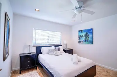 a white bedroom with a bed and a ceiling fan at A 1bedroom Las Olas on the water in Fort Lauderdale