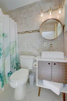 a bathroom with a toilet and a sink and a mirror at LoKal Rental Tropical Florida destination in Fort Lauderdale