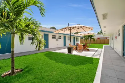 a patio with two tables and an umbrella at LoKal Rental Tropical Florida destination in Fort Lauderdale