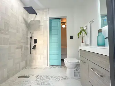 a bathroom with a toilet and a blue door at 3 Seasons at the Carrington 3 Two Bedroom 1 Bath Apts -6 Bedrooms 3 bathrooms and 3 bedroom 2 bathroom Villa in Miami