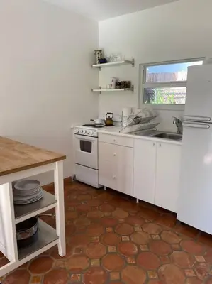 a white kitchen with a sink and a stove at Miami guest house with large pool in Miami