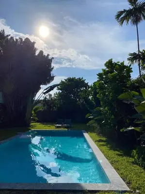 a blue swimming pool in a yard with trees at Miami guest house with large pool in Miami