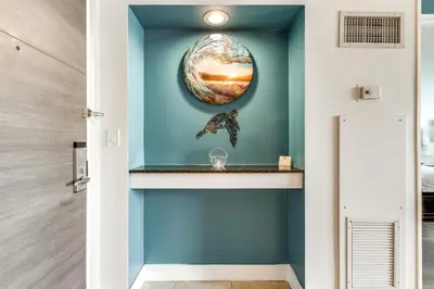 a hallway with a blue wall with a shelf at Modern Ft Lauderdale Condo about 7 Mi to Airport! in Fort Lauderdale