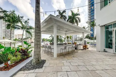 a pavilion with tables and chairs on a patio with palm trees at Modern Ft Lauderdale Condo about 7 Mi to Airport! in Fort Lauderdale