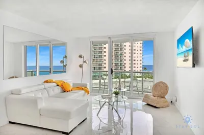 a white living room with a white couch and a glass table at Special Offer - Balcony - Beachfront Condo - Gym in Hollywood