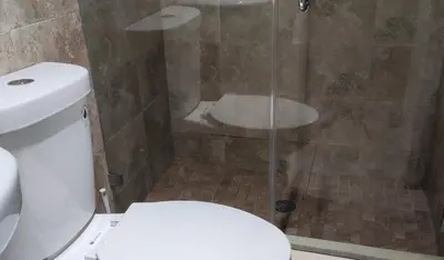 a bathroom with a shower with a toilet and a glass door at Summer Gardens in Miami