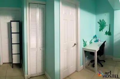a room with a white door and a desk and a sink at Summer Gardens in Miami