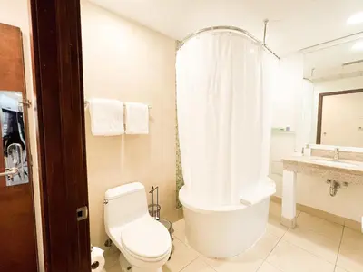 a bathroom with a tub and a toilet and a sink at Rooftop-Pool Suite with King Bed in Ocean Dr C303 in Miami Beach