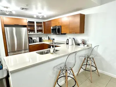 a kitchen with a counter and two bar stools at Beautiful 1BD 1BTH at Midblock FREE PARKING in Miami