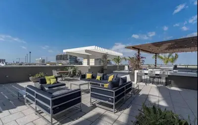 a patio with couches and tables on a roof at Beautiful 1BD 1BTH at Midblock FREE PARKING in Miami