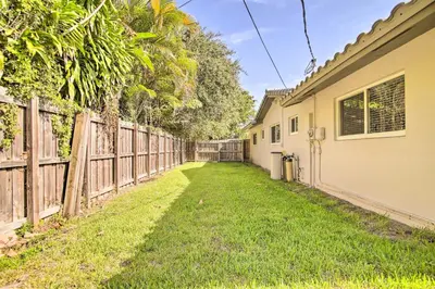 a house with a fence and a yard at Wilton Manors Home with Pool about 4 Mi to Beach! in Fort Lauderdale
