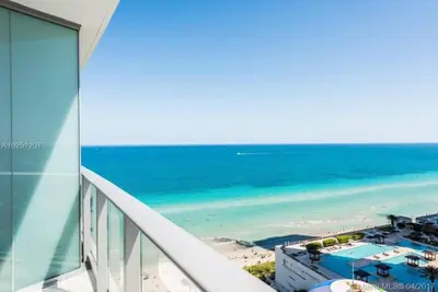 a view of the beach from the balcony of a building at Modern Beachfront Condo with Stunning Ocean View in Hollywood