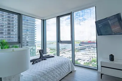 a bedroom with a bed and large windows at Luxurious 2-Bed Apartment with Breathtaking Bay views!! in Miami