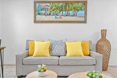 a living room with a gray couch with yellow pillows at Walnut By The Sea in Hollywood