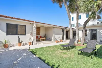 a yard with two chairs and a house at Walnut By The Sea in Hollywood