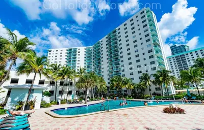 a resort swimming pool with palm trees and buildings at The Tides apartment Go Holiday Home 5th floor in Hollywood