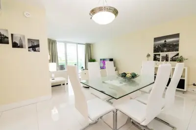 a dining room with a glass table and white chairs at The Tides apartment Go Holiday Home 5th floor in Hollywood