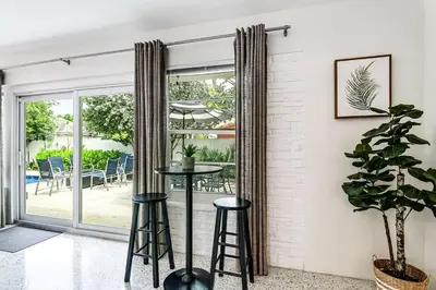 a living room with a table and chairs at *Victoria Park Pool Home- close to beach/Las Olas* in Fort Lauderdale