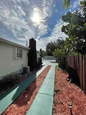a sidewalk in front of a house with a fence at “La Casita” Beautiful home in the heart of Miami ! in Miami