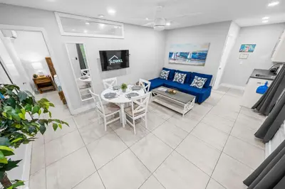 a living room with a table and a blue couch at Casa Cordova Apartments By Lowkl in Fort Lauderdale
