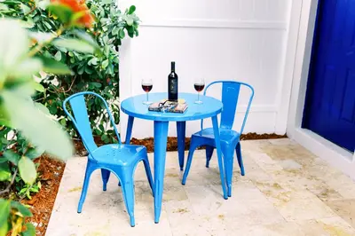 a blue table with two chairs and a bottle of wine at Casa Cordova Apartments By Lowkl in Fort Lauderdale