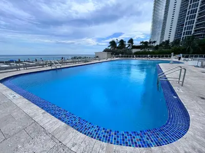 a large blue swimming pool next to the ocean at Lovely beaches ocean & city view in Miami Beach