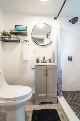 a bathroom with a toilet and a sink and a mirror at Cozy Studio w/gated parking in Miami