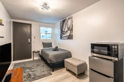 a small bedroom with a bed and a television at Cozy Studio w/gated parking in Miami