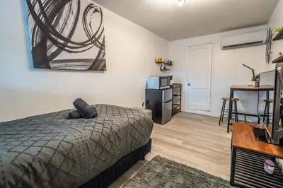 a bedroom with a bed and a television and a desk at Cozy Studio w/gated parking in Miami