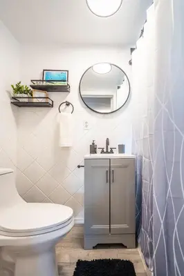a bathroom with a white toilet and a mirror at Cozy Studio w/gated parking in Miami