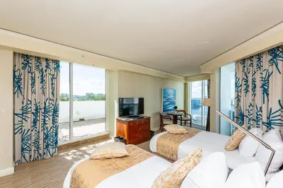 a hotel room with two beds and a large window at TRUMP INTERNATIONAL BEACH RESORT 2 BEDROOM APARTMENT 1600 Sf Ocean and Bay View With Terrace in Miami Beach
